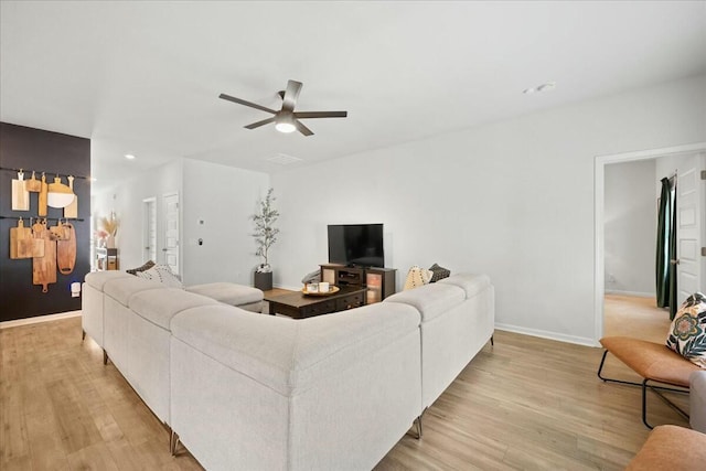 living area with recessed lighting, light wood-type flooring, a ceiling fan, and baseboards