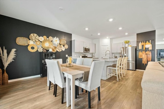 dining space featuring recessed lighting, light wood-type flooring, and baseboards