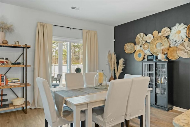 dining room featuring beverage cooler, visible vents, and wood finished floors