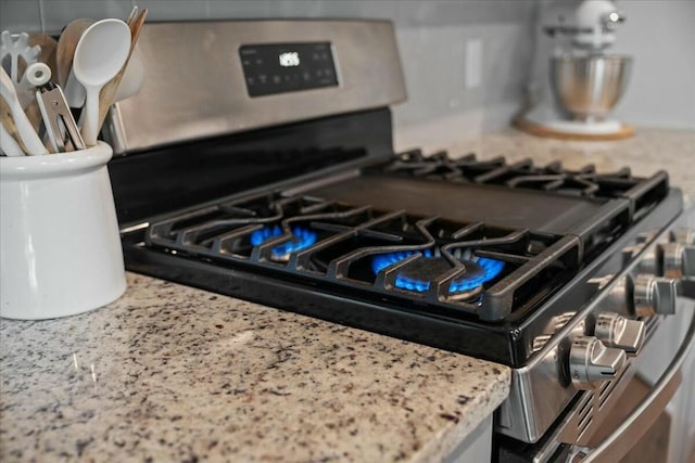 room details featuring light stone counters and stainless steel gas stove