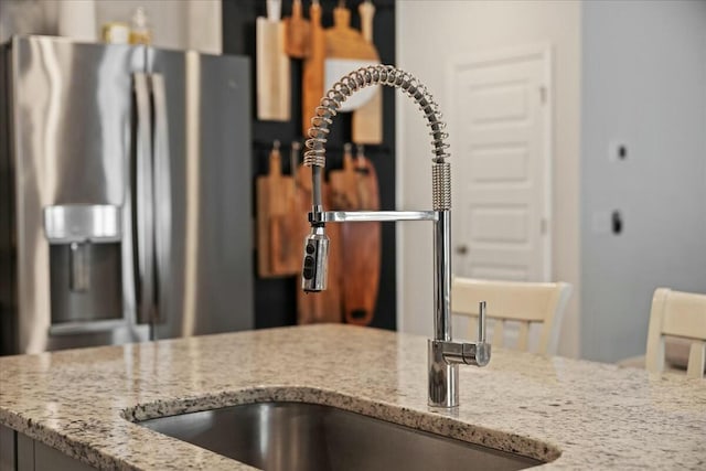 room details with light stone counters and a sink