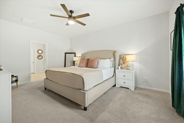 bedroom with light colored carpet, ceiling fan, and baseboards