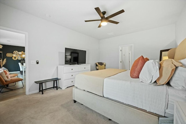 bedroom featuring light carpet, ceiling fan, and baseboards