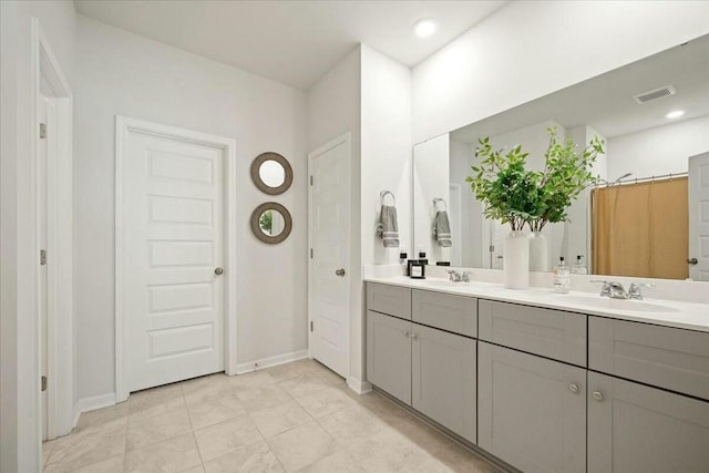 full bath with double vanity, recessed lighting, visible vents, a sink, and baseboards