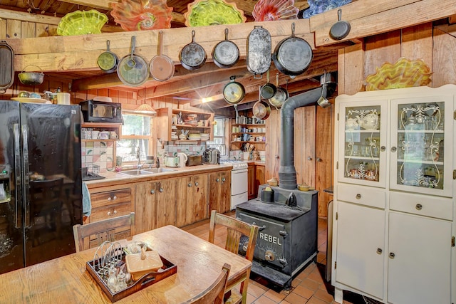 1373 Bridge St, Branchville, SC 29432 - kitchen with black appliances, a wood stove, open shelves, a sink, and light countertops
