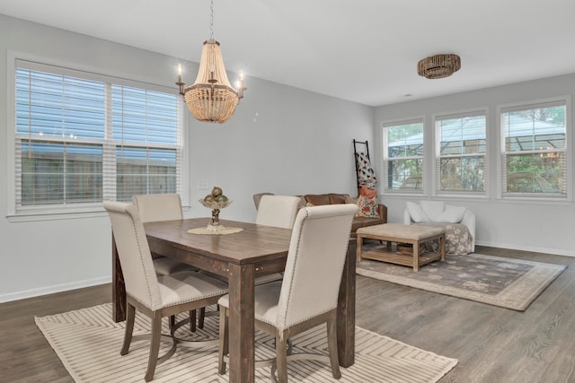 dining room with dark hardwood / wood-style flooring and a notable chandelier