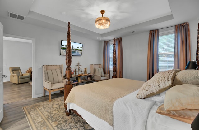 bedroom featuring hardwood / wood-style floors and a raised ceiling