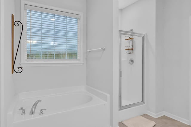 bathroom featuring tile patterned flooring and shower with separate bathtub