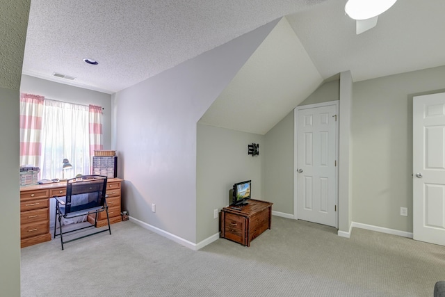 office featuring lofted ceiling, visible vents, light carpet, a textured ceiling, and baseboards