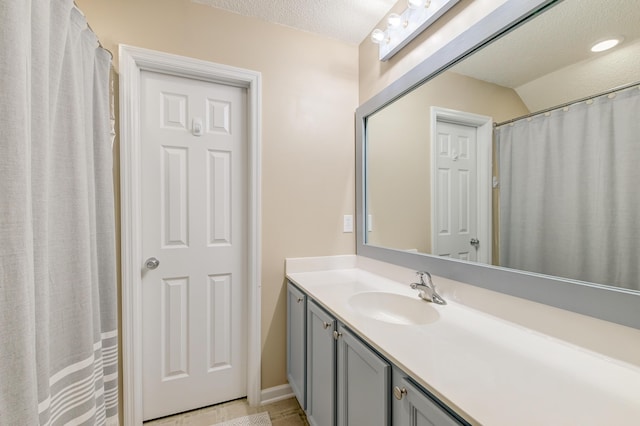 full bath featuring a textured ceiling and vanity