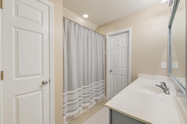 bathroom featuring curtained shower, a textured ceiling, and vanity