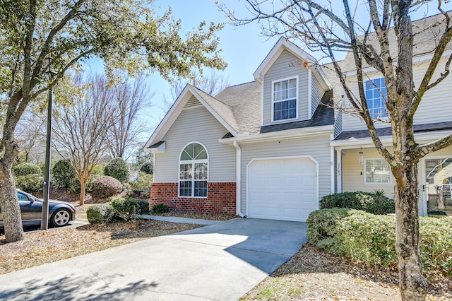 view of front of home with driveway, roof with shingles, and brick siding