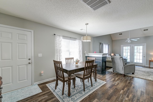 dining space with lofted ceiling, visible vents, dark wood-style flooring, and a wealth of natural light