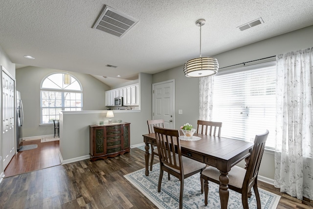 dining room featuring baseboards, visible vents, and dark wood finished floors