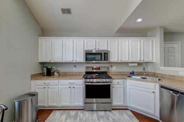 kitchen with white cabinetry, visible vents, appliances with stainless steel finishes, and a sink