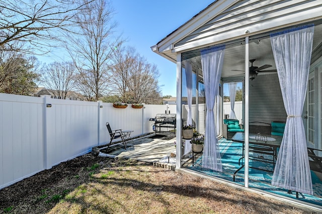 view of yard featuring ceiling fan, a fenced backyard, and a gate