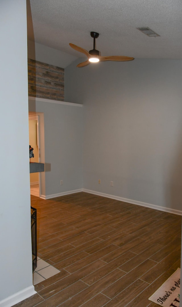 spare room featuring dark wood-type flooring, ceiling fan, and a textured ceiling