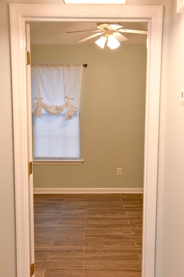 spare room with dark hardwood / wood-style flooring and ceiling fan