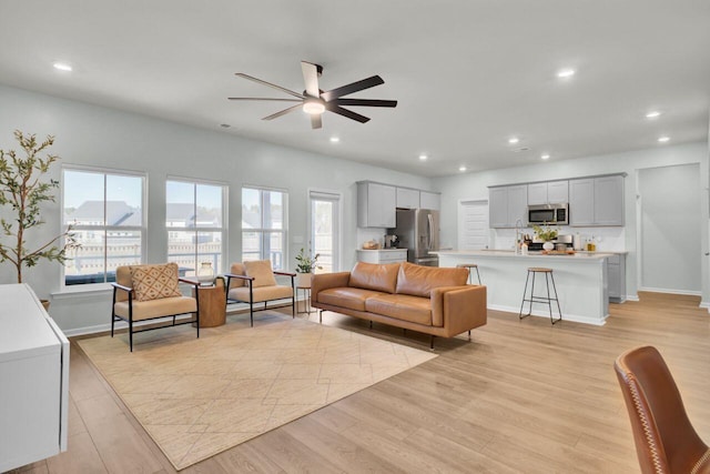 living area with a wealth of natural light, light wood finished floors, and recessed lighting