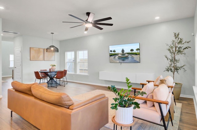 living room with recessed lighting, baseboards, and wood finished floors