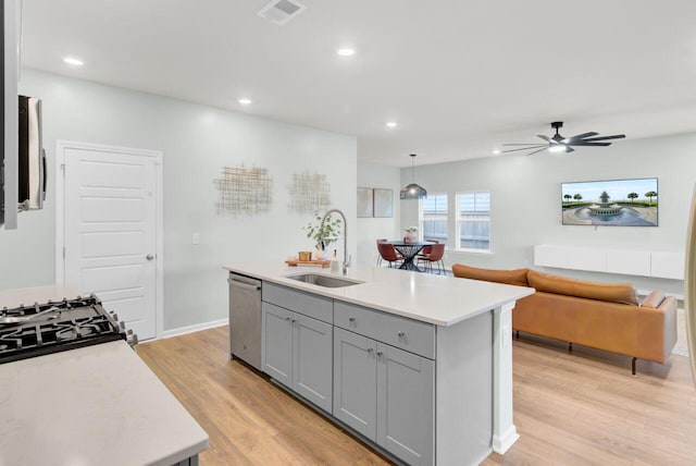 kitchen featuring visible vents, appliances with stainless steel finishes, light countertops, gray cabinetry, and a sink