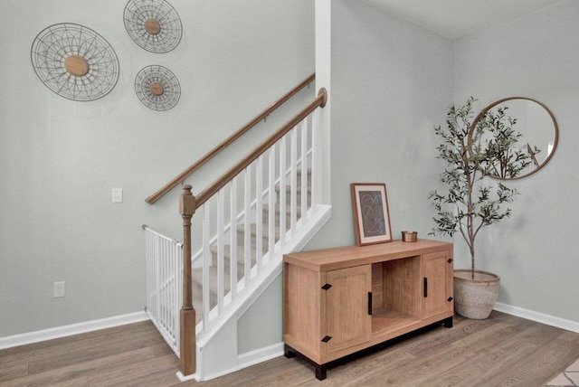 stairs featuring wood finished floors and baseboards