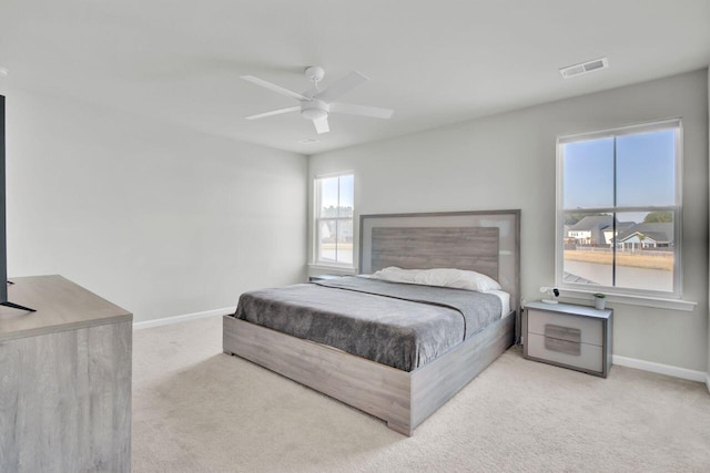 carpeted bedroom featuring ceiling fan, visible vents, and baseboards