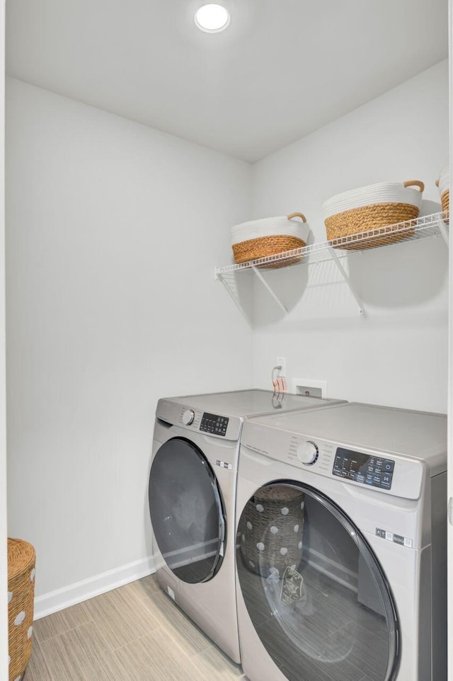 laundry area with laundry area, independent washer and dryer, and baseboards