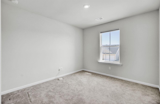 carpeted empty room featuring visible vents and baseboards