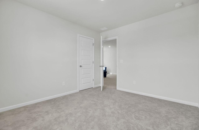 empty room with light colored carpet and baseboards