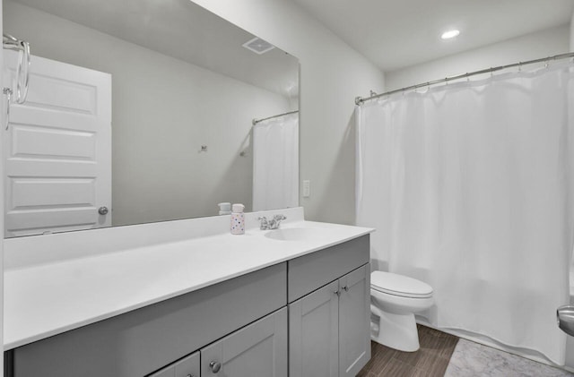 bathroom featuring toilet, shower / tub combo, visible vents, and vanity