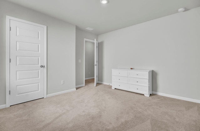 unfurnished bedroom featuring light colored carpet and baseboards