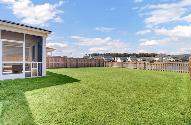 view of yard featuring a sunroom and a fenced backyard