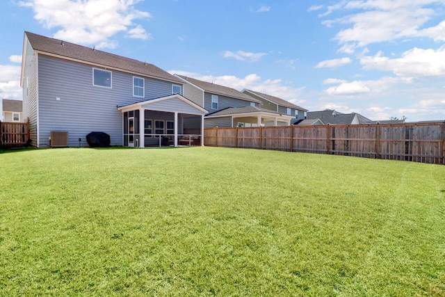 rear view of house with a sunroom, central AC, a yard, and fence