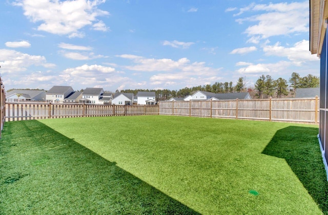 view of yard with a fenced backyard and a residential view