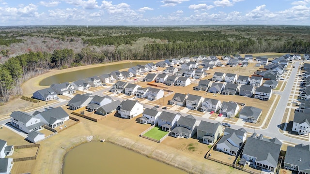 bird's eye view featuring a residential view, a water view, and a view of trees