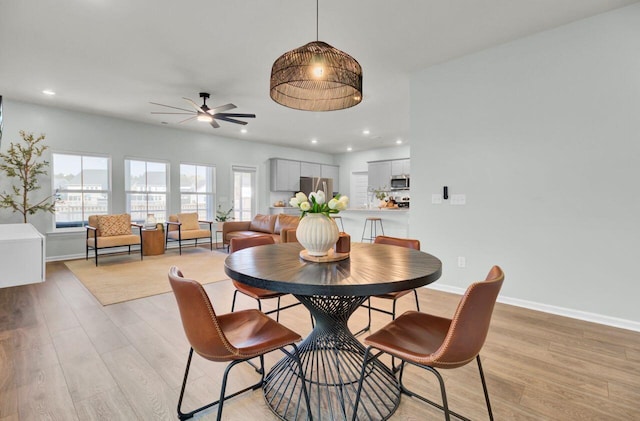 dining area with light wood finished floors, baseboards, a ceiling fan, and recessed lighting