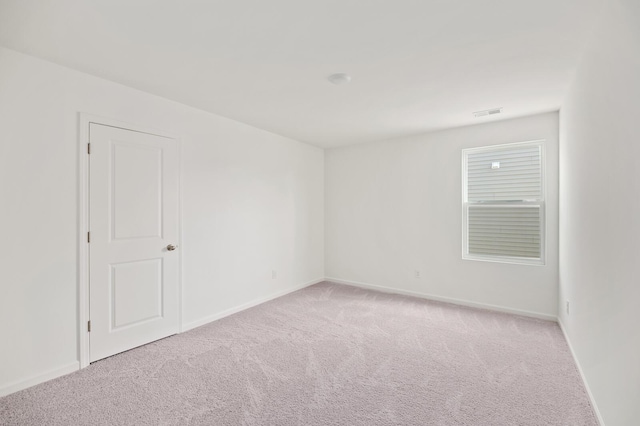 carpeted spare room featuring baseboards