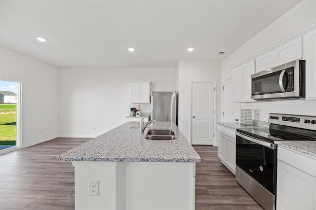 kitchen with white cabinetry, appliances with stainless steel finishes, a sink, and wood finished floors