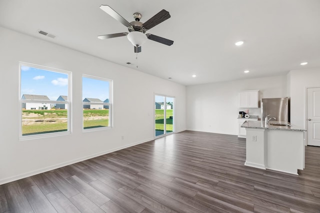 unfurnished living room with ceiling fan, recessed lighting, visible vents, baseboards, and dark wood finished floors