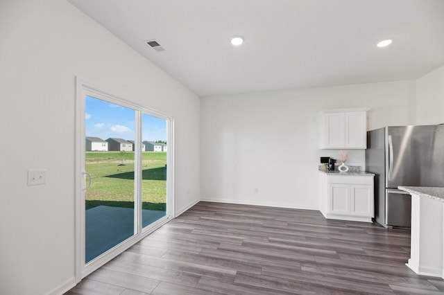 interior space with baseboards, visible vents, wood finished floors, and recessed lighting