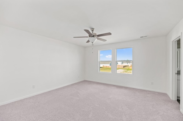 empty room with visible vents, ceiling fan, light carpet, and baseboards