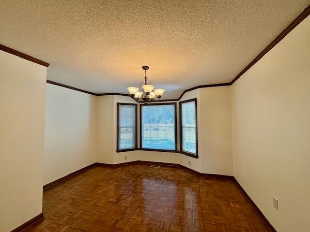 unfurnished room featuring dark parquet flooring, crown molding, a textured ceiling, and an inviting chandelier