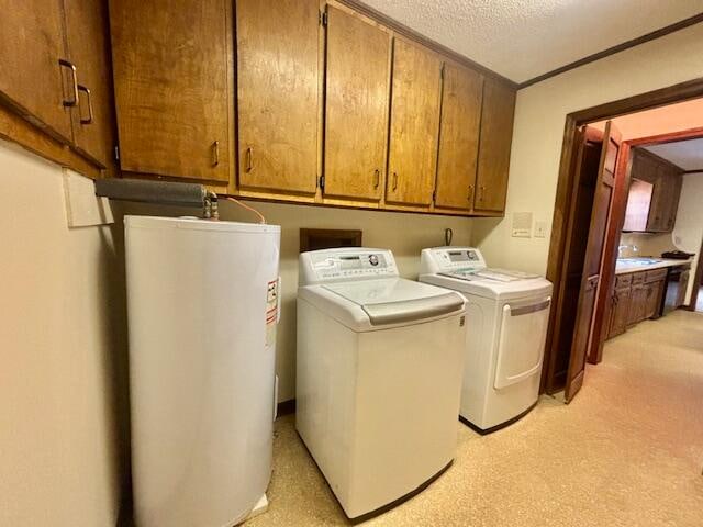 washroom with sink, independent washer and dryer, a textured ceiling, water heater, and cabinets