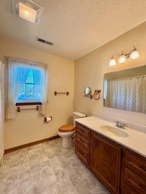 bathroom featuring vanity, toilet, and a textured ceiling