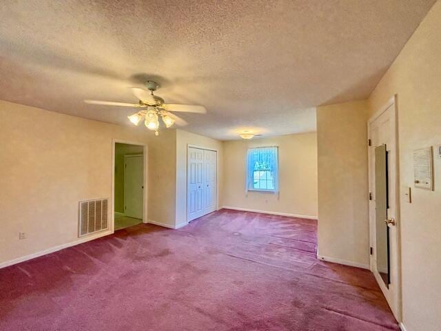 spare room featuring carpet floors, a textured ceiling, and ceiling fan