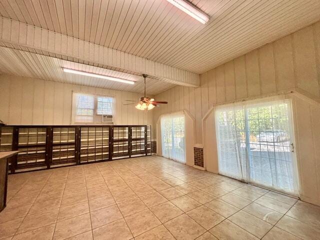 spare room featuring a wealth of natural light, light tile patterned flooring, wood ceiling, and ceiling fan