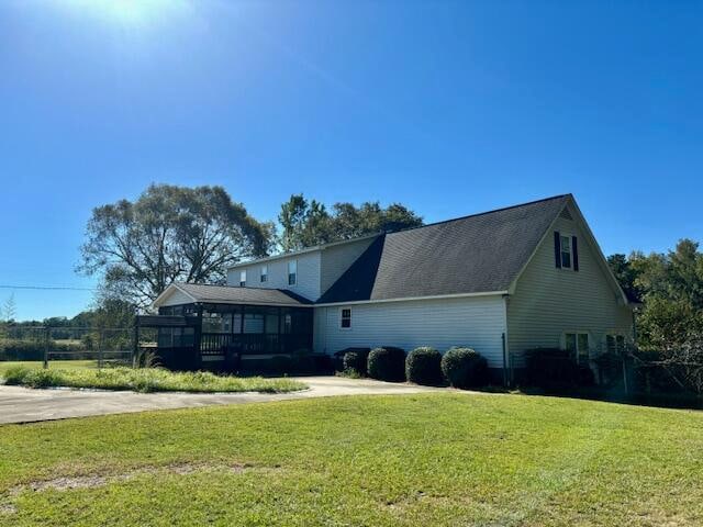 rear view of house featuring a deck and a lawn