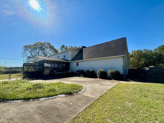 view of front of property featuring a sunroom and a front yard