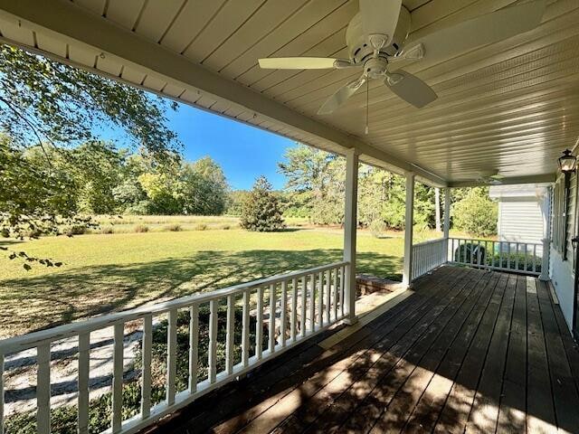 deck with a yard and ceiling fan